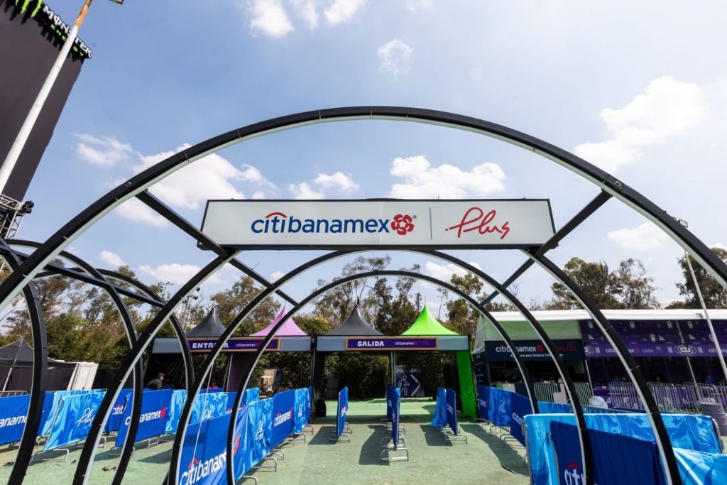 Acceso exclusivo del Área PLUS en EDC México con carriles diferenciados, señalización de entrada y salida, y estructura metálica con branding Banamex Plus durante el día.