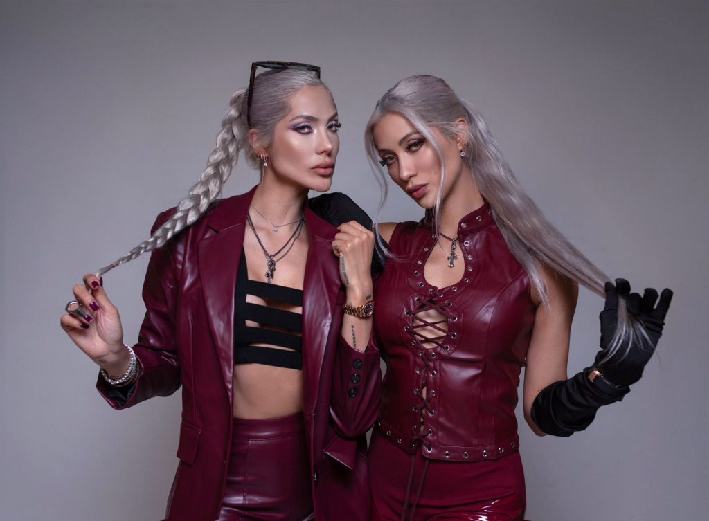 Le Twins vistiendo conjuntos de cuero rojo en sesión editorial, mostrando su identidad visual ligada a la electrónica.